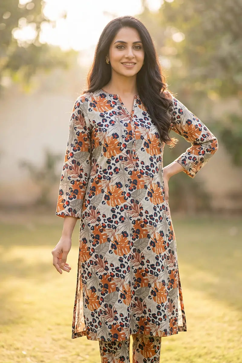 Woman modeling the Amber Jungle 2 piece allover printed lawn unstitched suit by Dorikhas, featuring a rust and navy tropical leaf print.