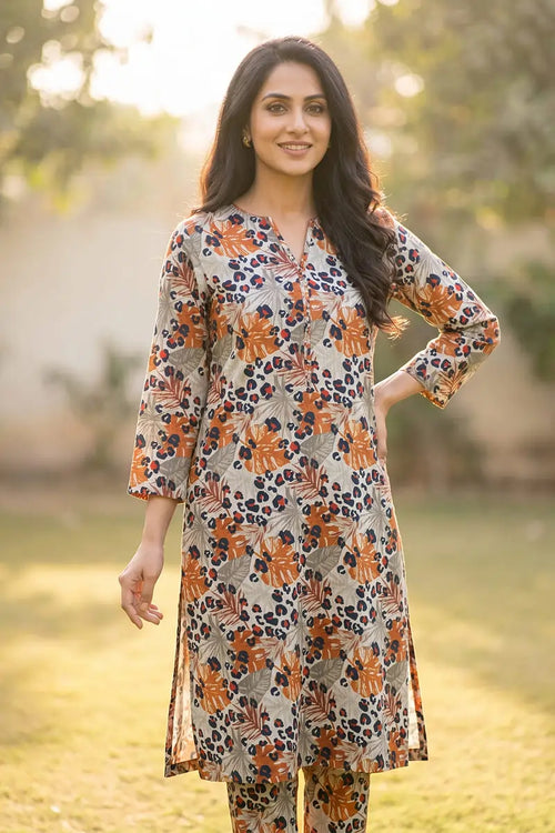 Woman modeling the Amber Jungle 2 piece allover printed lawn unstitched suit by Dorikhas, featuring a rust and navy tropical leaf print.